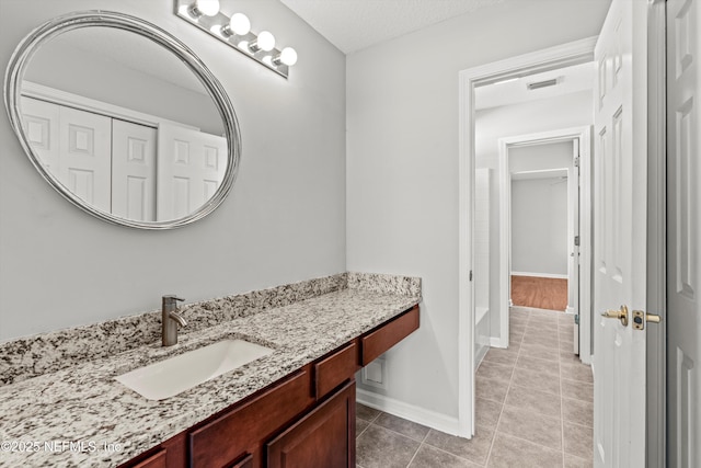 bathroom with tile patterned floors, vanity, and a textured ceiling