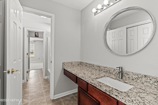 bathroom featuring tile patterned floors, vanity, and a textured ceiling