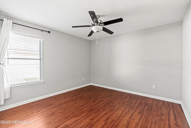 spare room featuring ceiling fan, a healthy amount of sunlight, a textured ceiling, and hardwood / wood-style flooring