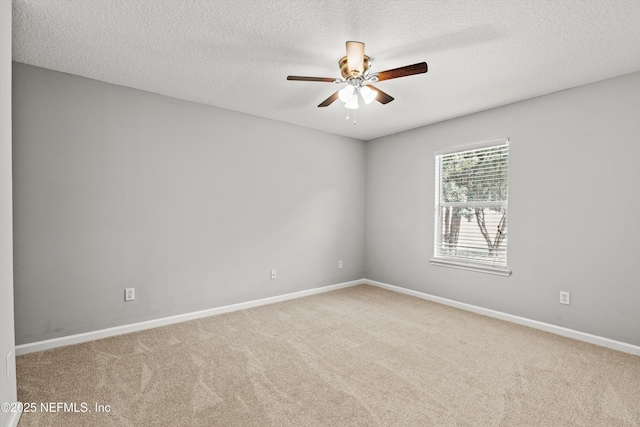 carpeted spare room featuring ceiling fan and a textured ceiling