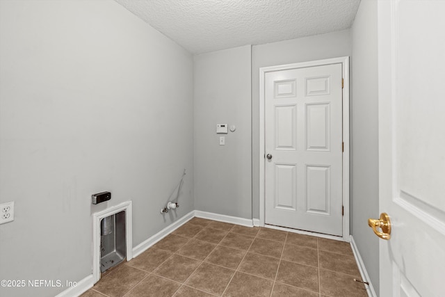 laundry room featuring a textured ceiling, dark tile patterned flooring, and gas dryer hookup