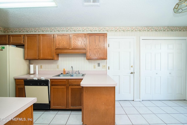 kitchen with sink, white appliances, light tile patterned floors, and a textured ceiling