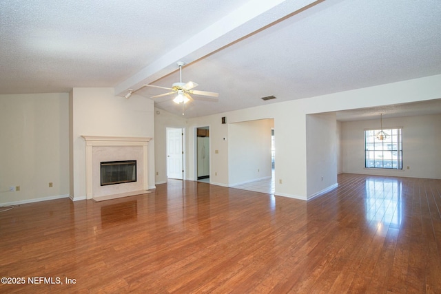 unfurnished living room featuring a textured ceiling, a premium fireplace, ceiling fan with notable chandelier, and wood-type flooring