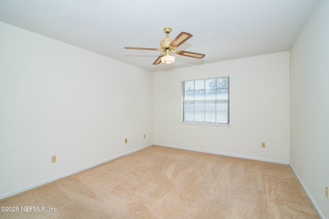 carpeted spare room featuring a textured ceiling and ceiling fan