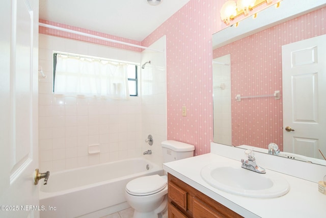 full bathroom featuring toilet, tiled shower / bath combo, vanity, and tile patterned floors