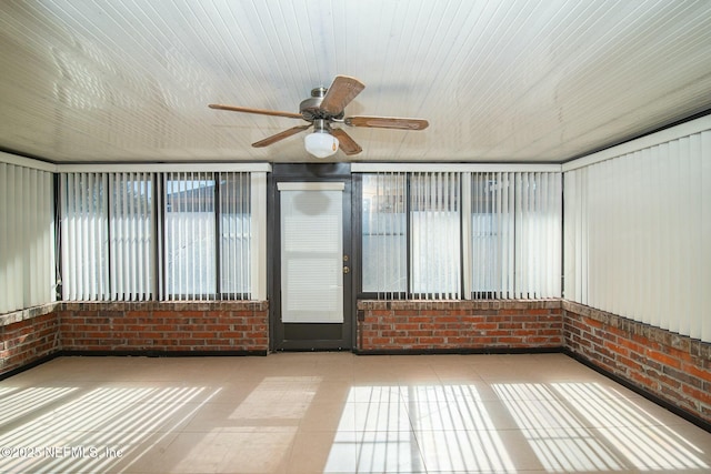 unfurnished sunroom with ceiling fan