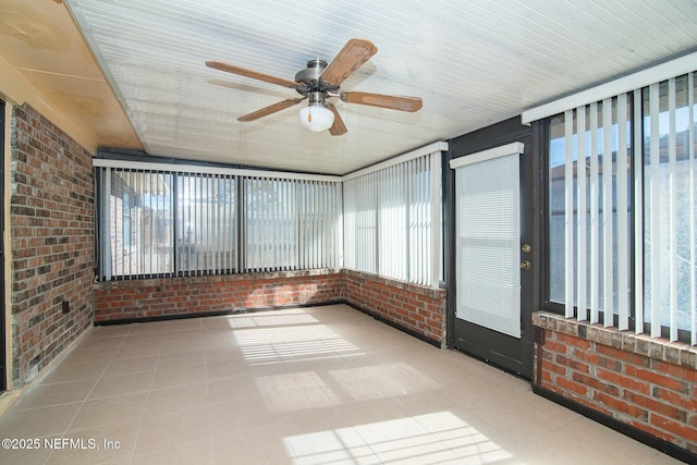 unfurnished sunroom with ceiling fan