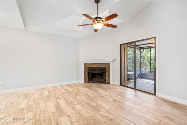 unfurnished living room with a fireplace, light wood-type flooring, vaulted ceiling, and ceiling fan