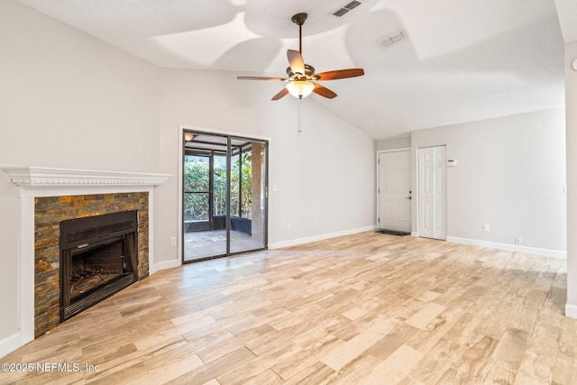 unfurnished living room with light wood-type flooring, a stone fireplace, ceiling fan, and lofted ceiling