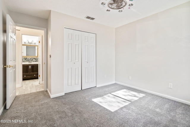 unfurnished bedroom featuring light carpet and a closet