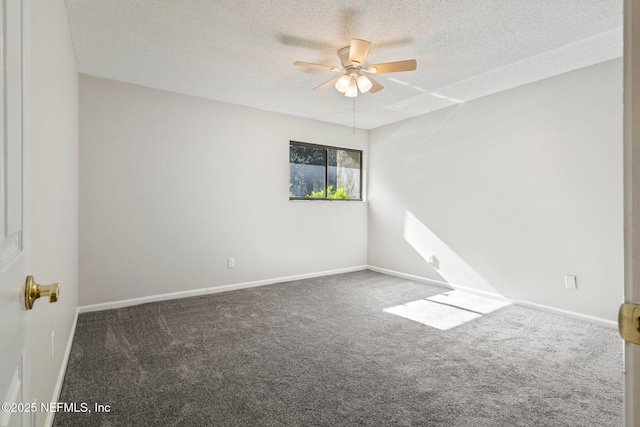 spare room featuring ceiling fan, dark carpet, and a textured ceiling