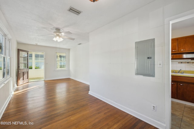 spare room featuring sink, ceiling fan, electric panel, and dark hardwood / wood-style floors