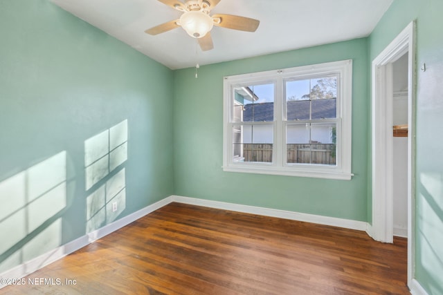 empty room featuring ceiling fan and dark wood-type flooring