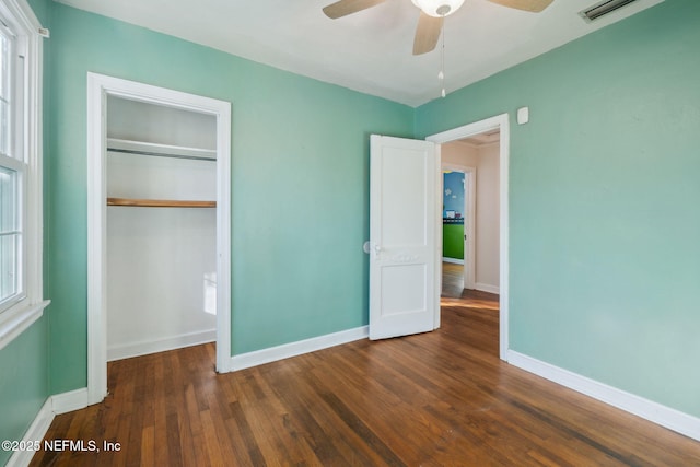 unfurnished bedroom with a closet, ceiling fan, and dark wood-type flooring