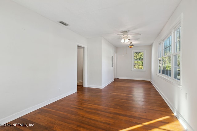 empty room with ceiling fan and dark hardwood / wood-style flooring