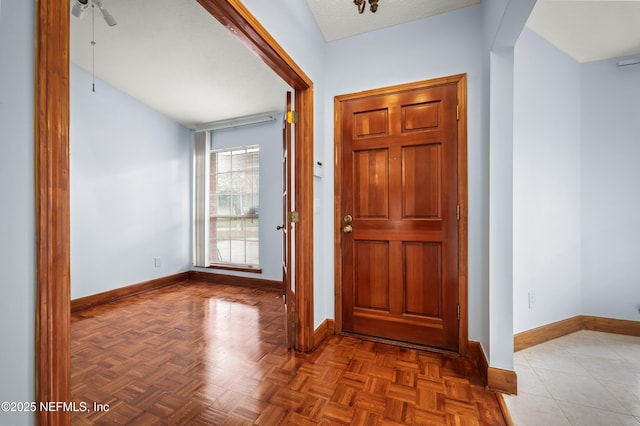 foyer entrance with dark parquet floors and ceiling fan