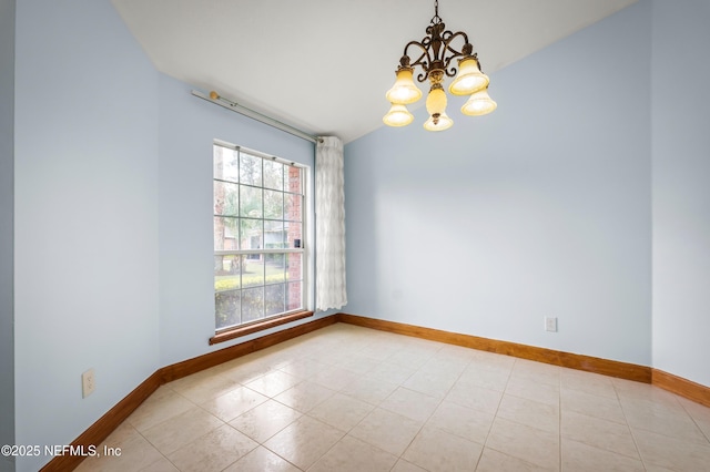 spare room featuring light tile patterned flooring and an inviting chandelier