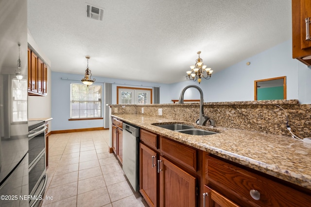 kitchen featuring sink, range, refrigerator, stainless steel dishwasher, and a notable chandelier