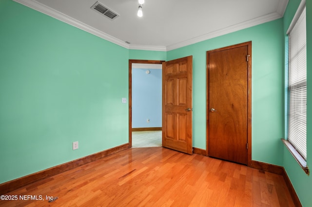 unfurnished bedroom featuring ornamental molding, light hardwood / wood-style floors, and multiple windows