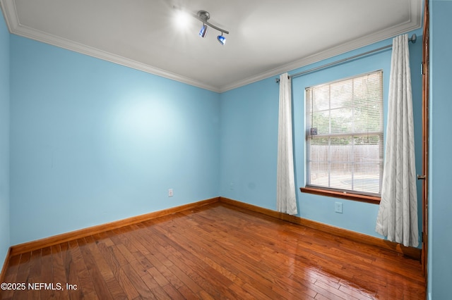 empty room featuring ornamental molding and hardwood / wood-style floors