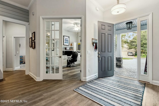 entrance foyer with ceiling fan, hardwood / wood-style floors, crown molding, and french doors