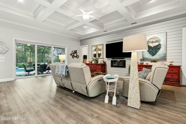 living room featuring coffered ceiling, wooden walls, ceiling fan, beam ceiling, and wood-type flooring