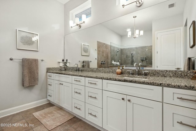 bathroom with a tile shower, tile patterned floors, vanity, and a notable chandelier