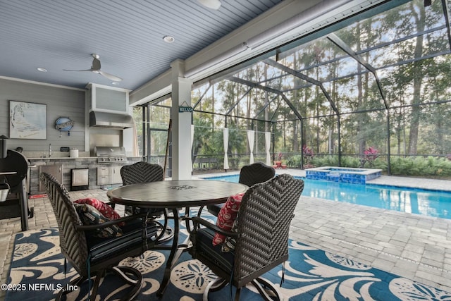 view of patio / terrace with grilling area, a pool with hot tub, ceiling fan, a lanai, and exterior kitchen