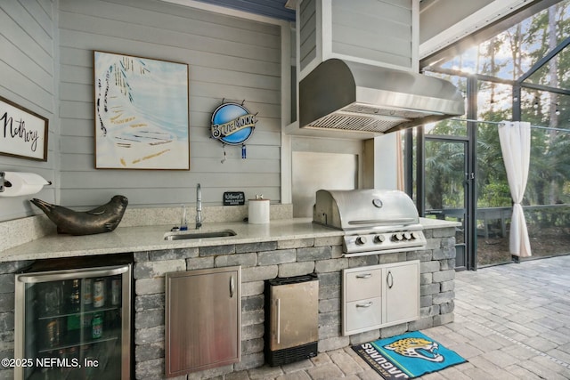 view of patio with glass enclosure, sink, exterior kitchen, wine cooler, and area for grilling