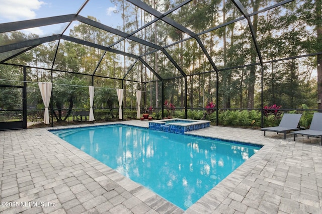 view of swimming pool with an in ground hot tub, glass enclosure, and a patio area