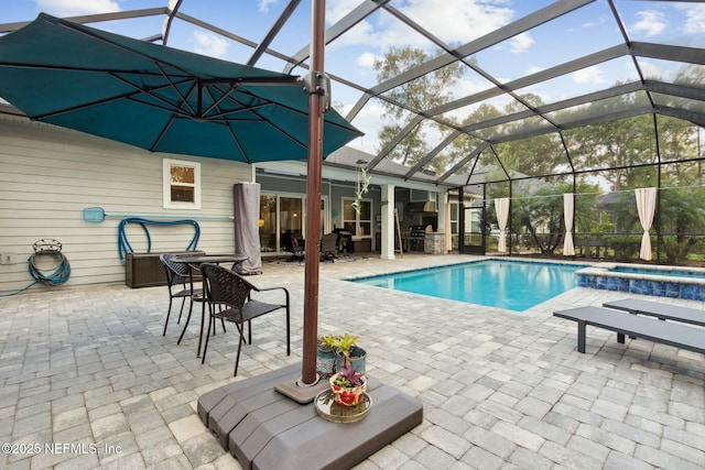 view of pool with a lanai, a patio area, and an in ground hot tub