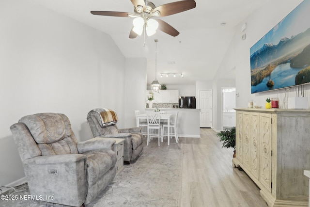 living room with light wood-type flooring, ceiling fan, and lofted ceiling