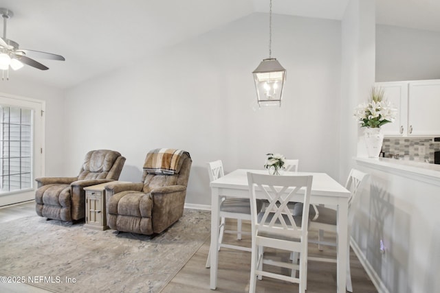 dining space featuring ceiling fan, light hardwood / wood-style flooring, and lofted ceiling