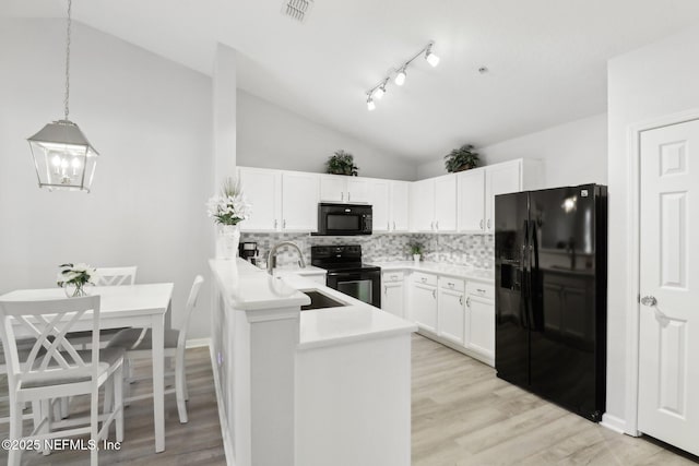 kitchen featuring decorative backsplash, kitchen peninsula, black appliances, pendant lighting, and white cabinets