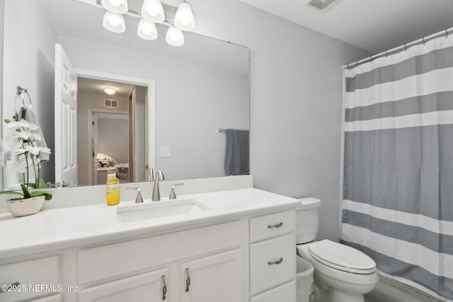 bathroom featuring a shower with shower curtain, vanity, and toilet