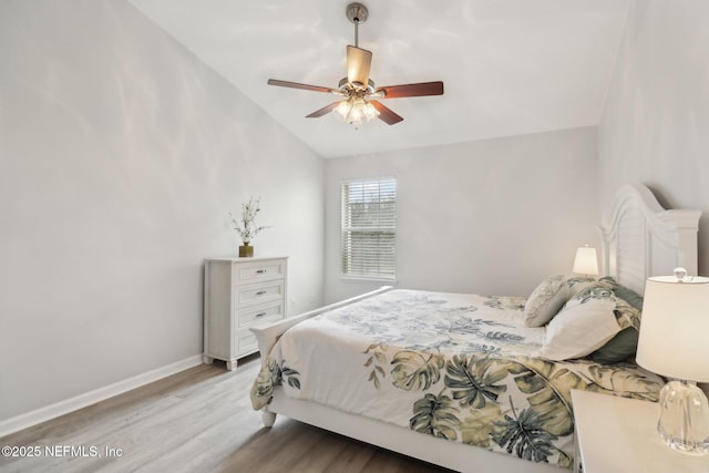 bedroom with ceiling fan, light hardwood / wood-style flooring, and vaulted ceiling