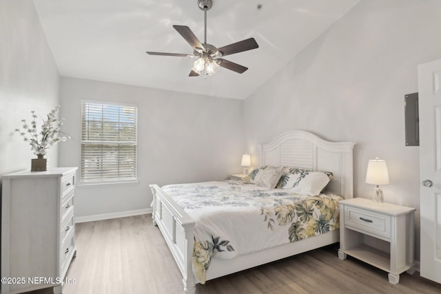 bedroom with electric panel, ceiling fan, wood-type flooring, and lofted ceiling