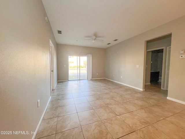 tiled spare room featuring ceiling fan