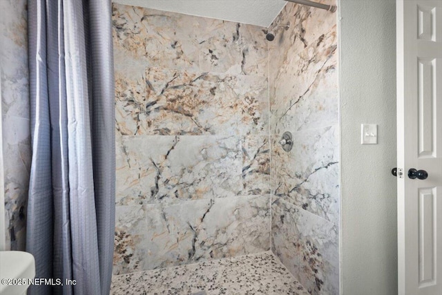 bathroom featuring a textured ceiling, toilet, and a shower with curtain