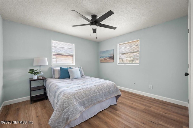 bedroom with a textured ceiling, ceiling fan, and hardwood / wood-style floors