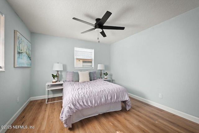 bedroom featuring a textured ceiling, ceiling fan, and light hardwood / wood-style flooring