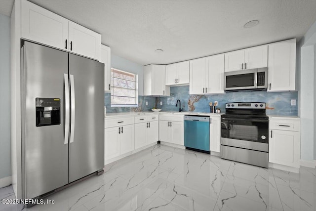 kitchen with decorative backsplash, white cabinets, and stainless steel appliances