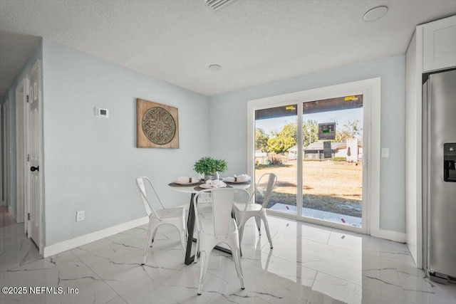 dining space featuring a textured ceiling