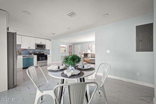 dining room with a textured ceiling and electric panel