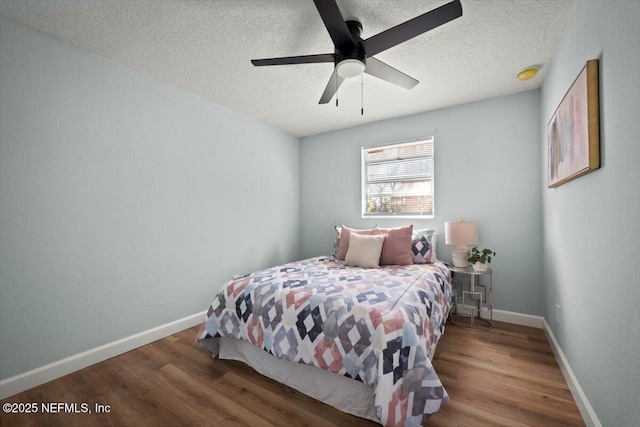 bedroom with ceiling fan, dark hardwood / wood-style flooring, and a textured ceiling