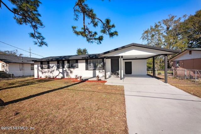 ranch-style home featuring a front lawn and a carport