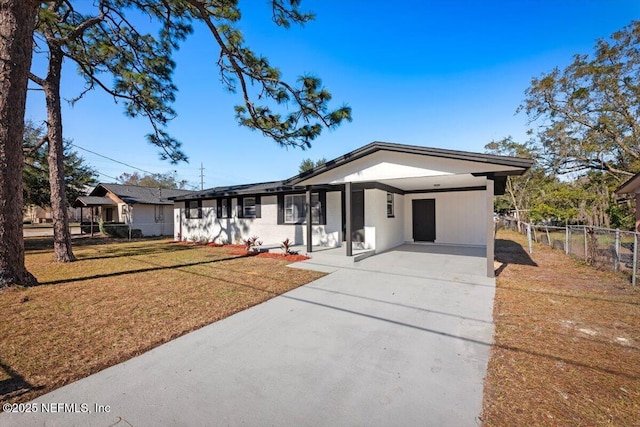 ranch-style house featuring a front lawn and a carport