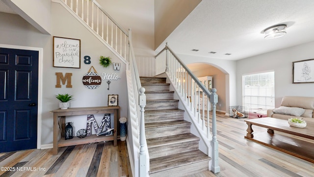 stairway featuring wood-type flooring and a textured ceiling