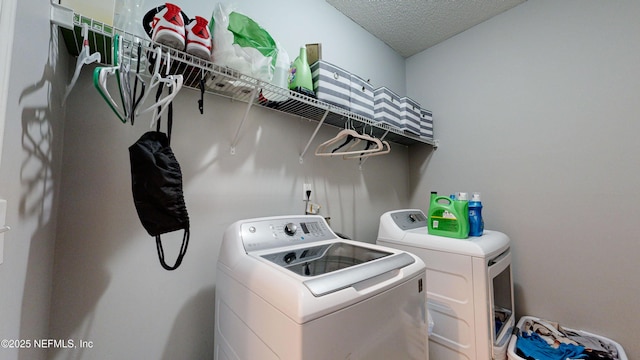 clothes washing area featuring independent washer and dryer and a textured ceiling