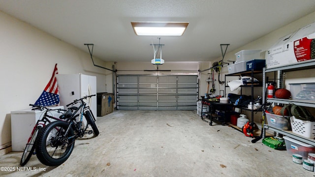 garage featuring white fridge and a garage door opener